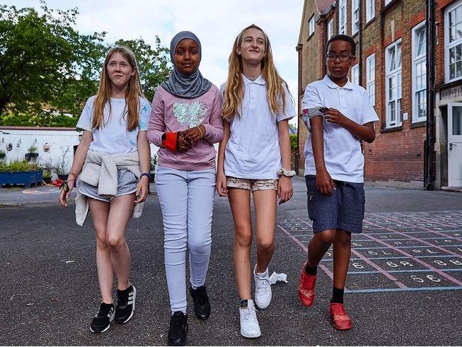 Four children wearing micro:bit step counters and activity monitors