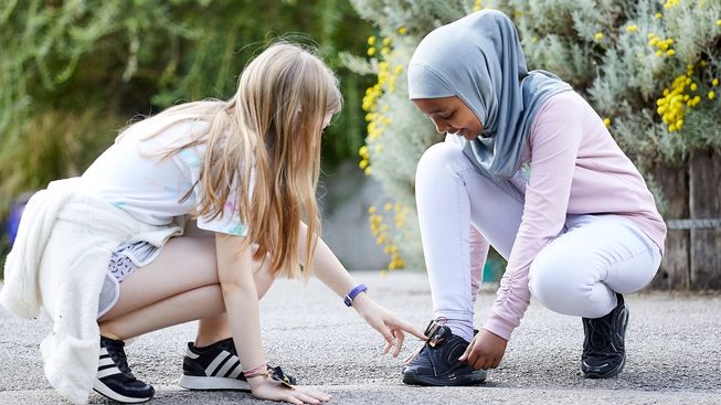 djevojka pokazuje micro:bitov brojač koraka na cipeli druge djevojke