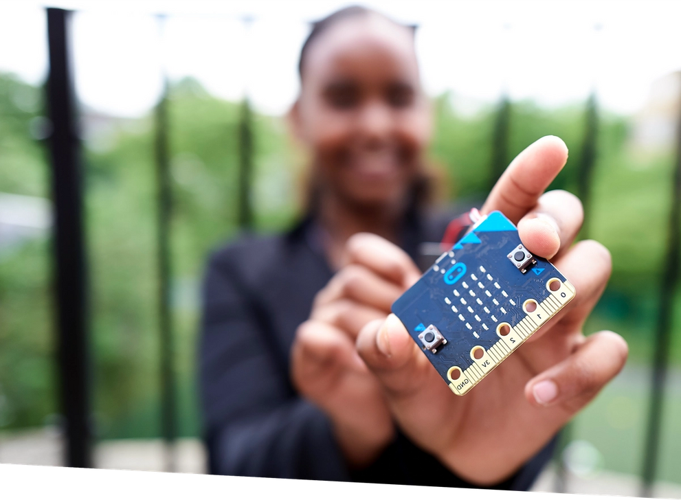a pupil holding a micro:bit up close to the viewer